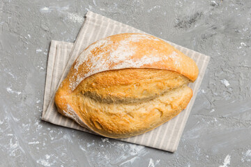 Freshly baked delicious french bread with napkin on rustic table top view. Healthy white bread loaf