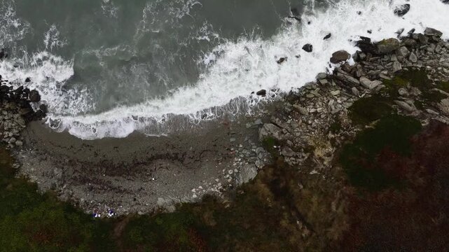 View of the coast of Howth Head in Dublin Ireland. Waves of the Atlantic Ocean crashing upon the rocky shore.