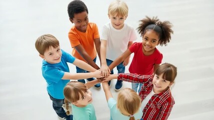 A diverse group of children stack their hands in a show of unity