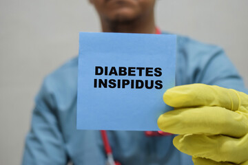 Doctor holds in hands a card with the name of the Diabetes Insipidus. Medical concept