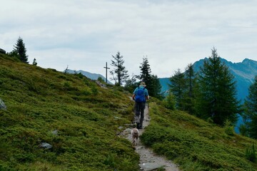 Mann und sein Lagotto Romagnolo Hund wandern im Ultental in S&uuml;dtirol 