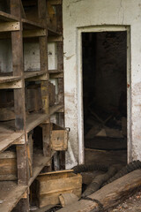 Entrepôt abandonné. Vieilles étagères en bois devant une porte. Ancienne entreprise en faillite.