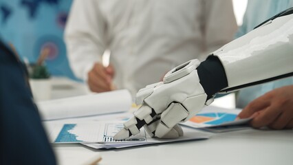 A robotic hand is interacting with documents during a business meeting, symbolizing the fusion of...