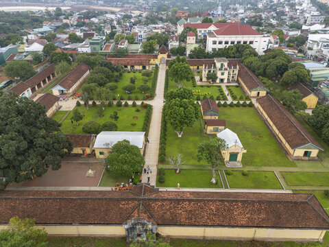 Aerial view of the Dak Lak Museum, a colonial-era architectural gem with vibrant green lawns contrasting with the terracotta roofs, Buon Ma Thuot, Dak Lak, Vietnam.