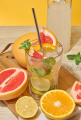 Glass with cold cocktail, citrus pieces inside, homemade drink