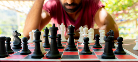 Portrait of a Serious Man Playing Chess Outdoors on a Sunny Day, Engaged in Strategic Thinking