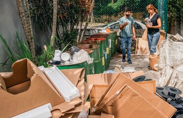 Volunteers examining separate waste collection bins outdoors