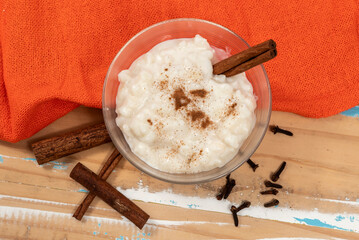 White corn cooked with milk known as canjica, hominy or mungunza, with cinnamon sticks, in a bowl