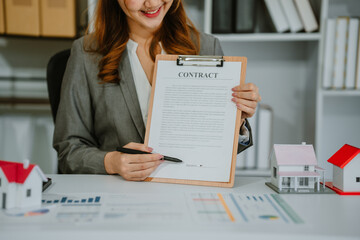 Closeup hands signing agreement document about buying home together at home, close-up hands of agent real estate giving document to elderly couple signature on contract with ownership residential.
