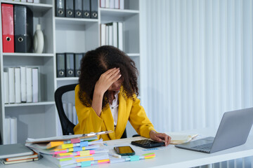Overwhelmed businesswoman at her desk. Stressed and frustrated while working on a project in her...