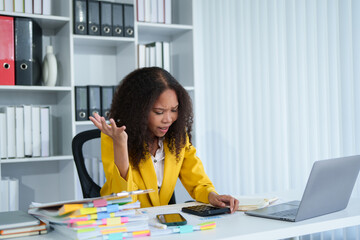 Overwhelmed businesswoman at her desk. Stressed and frustrated while working on a project in her...