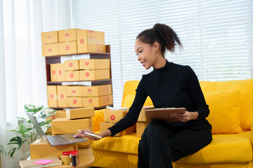 Online Shop Prep: A young woman meticulously prepares online shop orders at home. The scene...