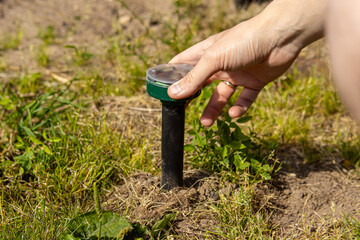 Man installs a rodent repeller in the ground. Protection of the garden from mice, moles and snakes