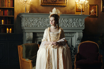 Caucasian young adult woman standing in ornate Baroque style room wearing historical Renaissance...