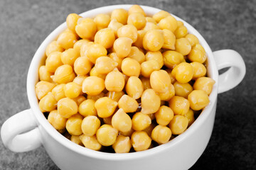 Chickpeas in white bowl on dark background for vegan protein, legume food or healthy eating concept