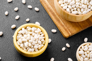 Multiple bowls with white beans on black background for food variety, vegan nutrition or culinary...
