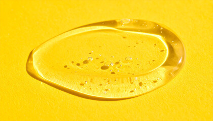 Transparent hyaluronic acid, gel or serum smear texture on yellow backdrop. Moisturizing, skin care.