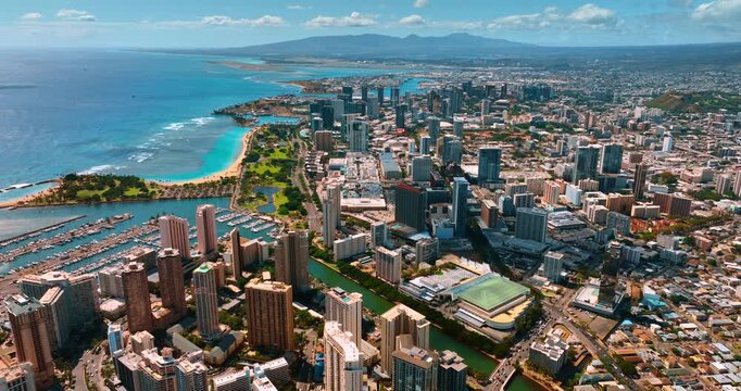 Beautiful panorama of modern Honolulu, Hawaii, USA on sunny day. Drone footage over Waikiki area approaching Ala Wai Canal.