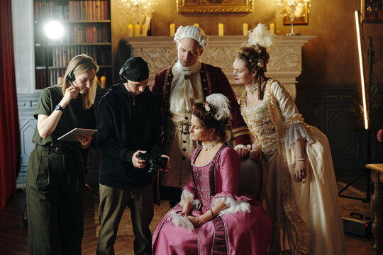 Group of young adult and middle aged Caucasian women and men in Baroque and Renaissance costumes standing and sitting - Powered by Adobe