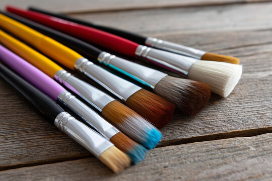 Colorful paintbrushes arranged neatly on a wooden surface