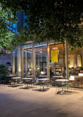 London restaurant in the night with panoramic windows and tables outside