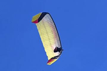 Tandem Paraglider flying in a blue sky	