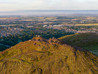 Aerial image of  Arthur's Seat peak in Edinburgh with people gathered to watch the sunset. 