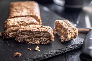 Halva with cocoa. Sweet oriental dessert on black table.