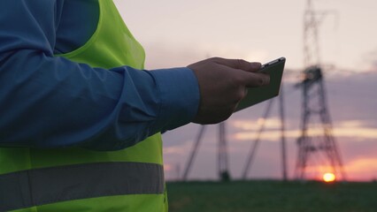 hands of an electrician working tablet at sunset. close up. engineering business concept....