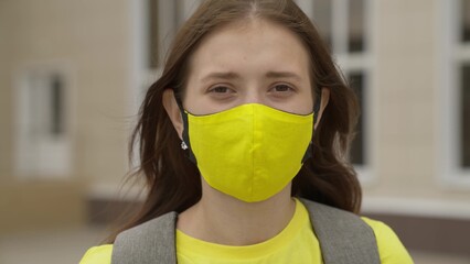 Young girl schoolgirl smiling in a protective mask, coronavirus pandemic, covid 19, safe walking...