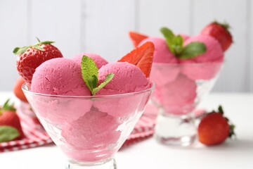 Refreshing sorbet, strawberries and mint in dessert bowl on white table against grey background,...