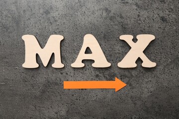 Word Max and arrow on grey table, flat lay