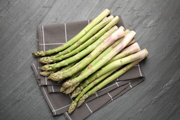 Fresh raw asparagus spears on black table, top view