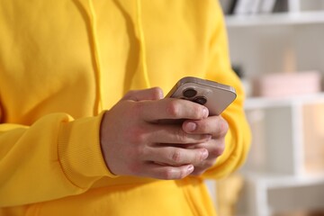 Teenage boy using smartphone at home, closeup