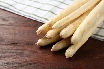 Raw asparagus spears on wooden table, closeup. Space for text