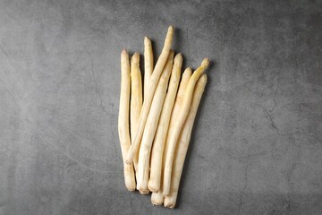 Many raw asparagus spears on grey table, flat lay