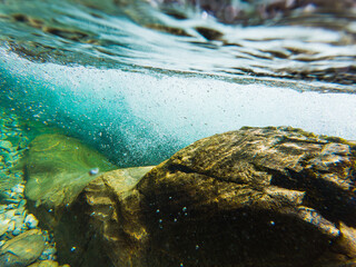A captivating underwater landscape in a fast-flowing river with crystal clear water, stones on the...