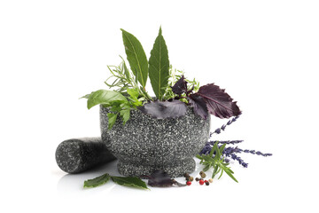 Mortar with pestle, different aromatic herbs and spices isolated on white