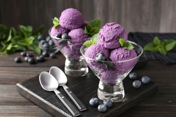 Tasty sorbet with blueberries and mint in dessert bowls on wooden table, closeup