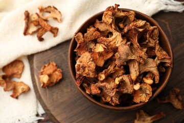 Dried chanterelle mushrooms on wooden table, flat lay