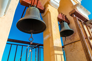 Obraz premium Bronze Bells Hanging Against Clear Blue Sky