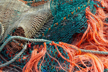 Pile of tangled commercial trawler fishing nets in bright green and orange colors