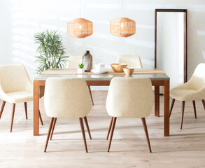 Scandinavian-inspired dining room with cream faux leather chairs, wooden table, rattan pendant...