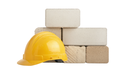 A yellow construction helmet resting against a stack of beige bricks.