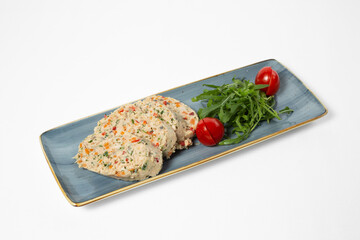 Steamed chicken cutlets with vegetables, served with tomatoes and arugula on a plate on a white background