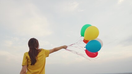 young girl with air beautiful balloons against blue sky. walk child nature. festive mood teenager....