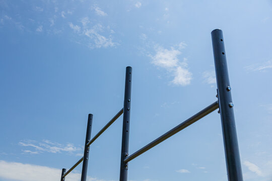Parallel bars stand in a sunlit gym setting, inviting users to practice exercises for strength and balance in a vibrant outdoor environment