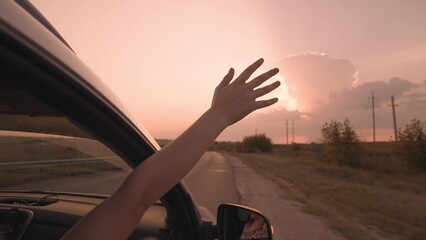 girl from a car catches wind with her hand at sunset, drive a car on a journey, drive on an asphalt...