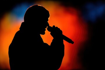 Shadow of an Artist: Black Silhouette of a Male Entertainer Holding a Microphone During a Live Concert