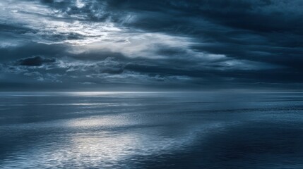 Obraz premium The serene ocean reflecting a moody twilight sky with dramatic clouds.